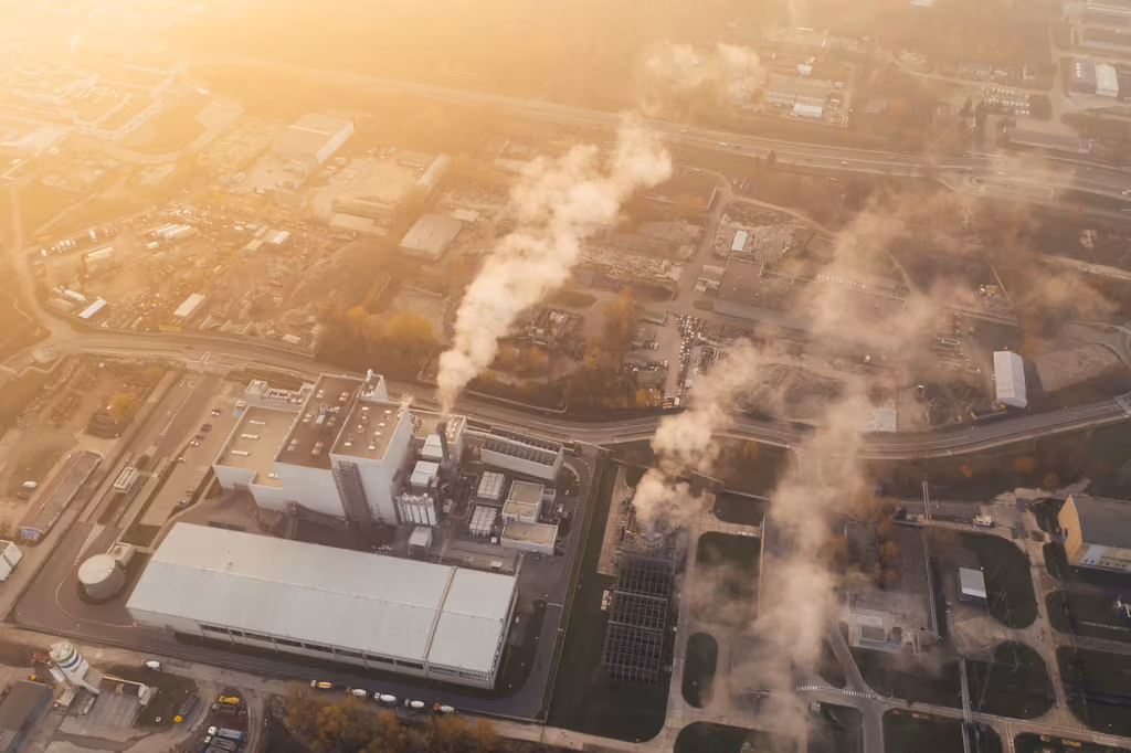 Industrial facility in Poznań releasing a large white plume of steam or smoke